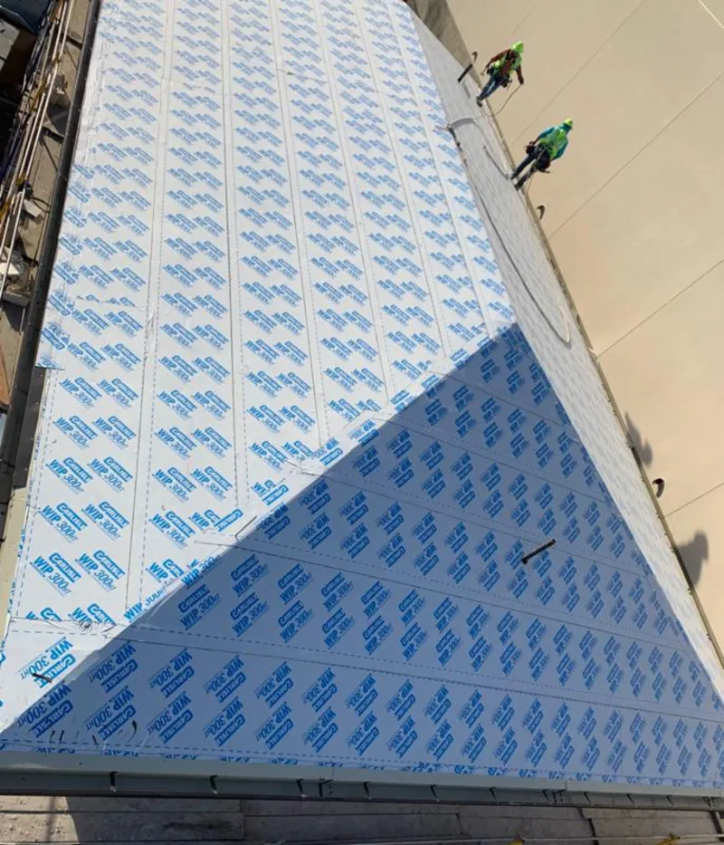 Professional roofers installing underlayment on a metal roof in Monticello